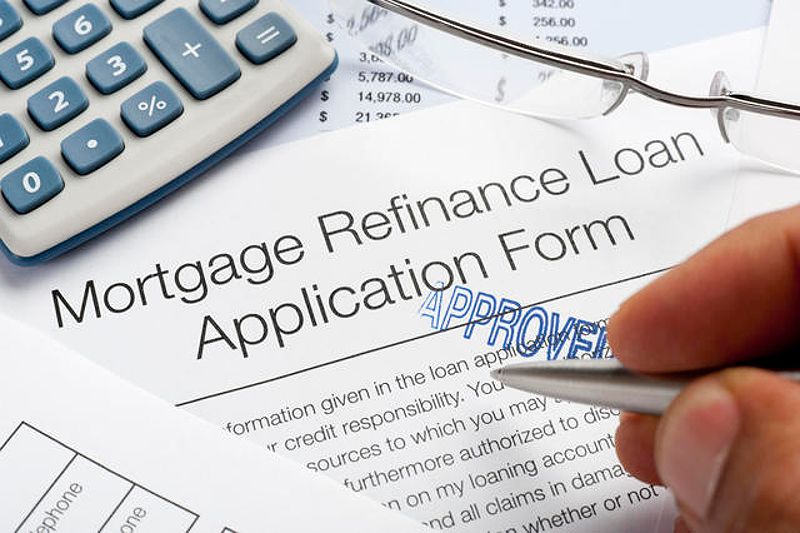 Approved Mortgage Refinance Application Form with pen and calculator