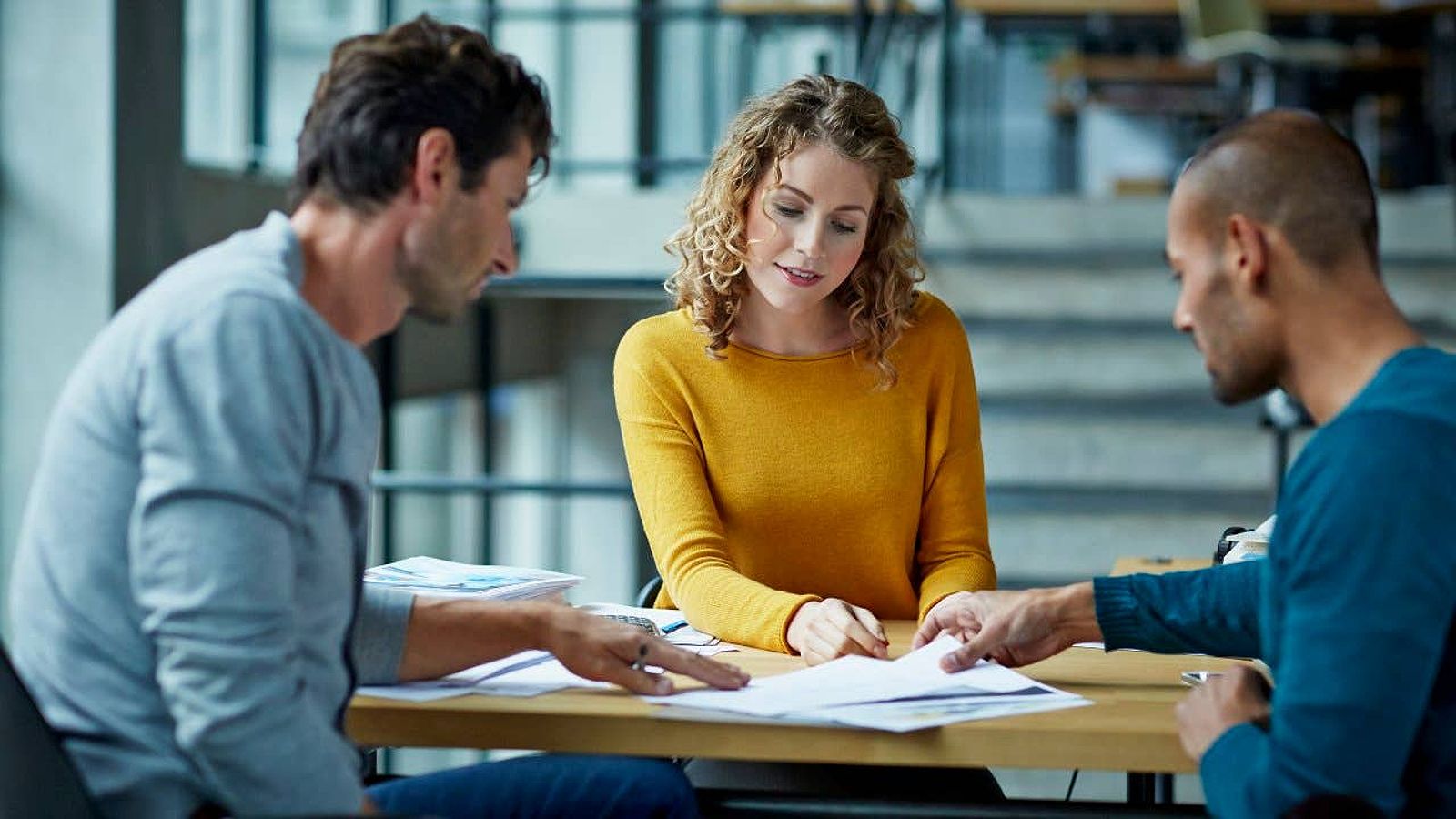 People sitting at a table, looking over documents together